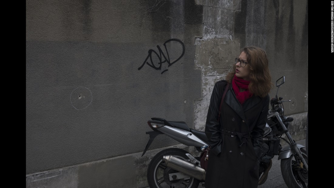 A woman observes bullet holes in a wall near the Paris restaurant Le Petit Cambodge on Saturday, November 14. 