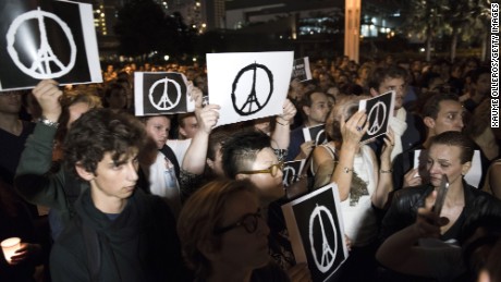 HONG KONG - NOVEMBER 14:  People hold peace signs as they gather during a memorial event for victims of the Paris terror attacks on November 14, 2015 in Hong Kong, Hong Kong. At least 120 people have been killed and over 200 injured, 80 of which seriously, following a series of terrorist attacks in the French capital.  (Photo by Xaume Olleros/Getty Images)