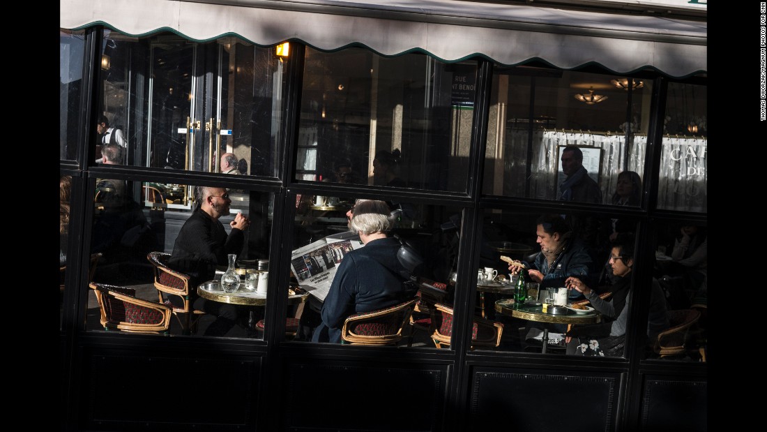 A woman reads a newspaper in the Cafe Les Deux Magots on November 15 In the St. Germain neighborhood of Paris.