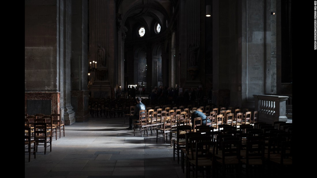 People sit inside the St. Sulpice Catholic church on November 15 in Paris. 