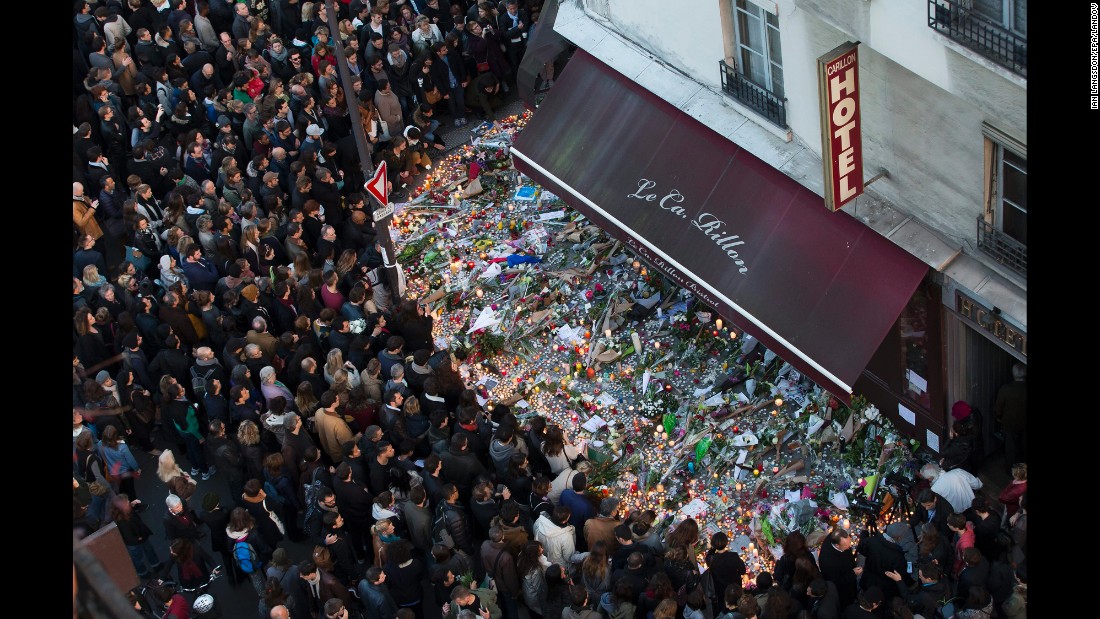 A large crowd gathers to lay flowers and candles in front of the Carillon restaurant in Paris on Sunday, November 15. 