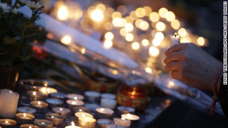 People place candles for the victims of a series of coordinated attacks in and around Paris, at the Place de la Republique square in Paris on November 14, 2015. At least 128 people were killed in the Paris attacks on the evening of November 13, with 180 people injured, 80 of them seriously, police sources told AFP.  AFP PHOTO / KENZO TRIBOUILLARD       (Photo credit should read KENZO TRIBOUILLARD/AFP/Getty Images)