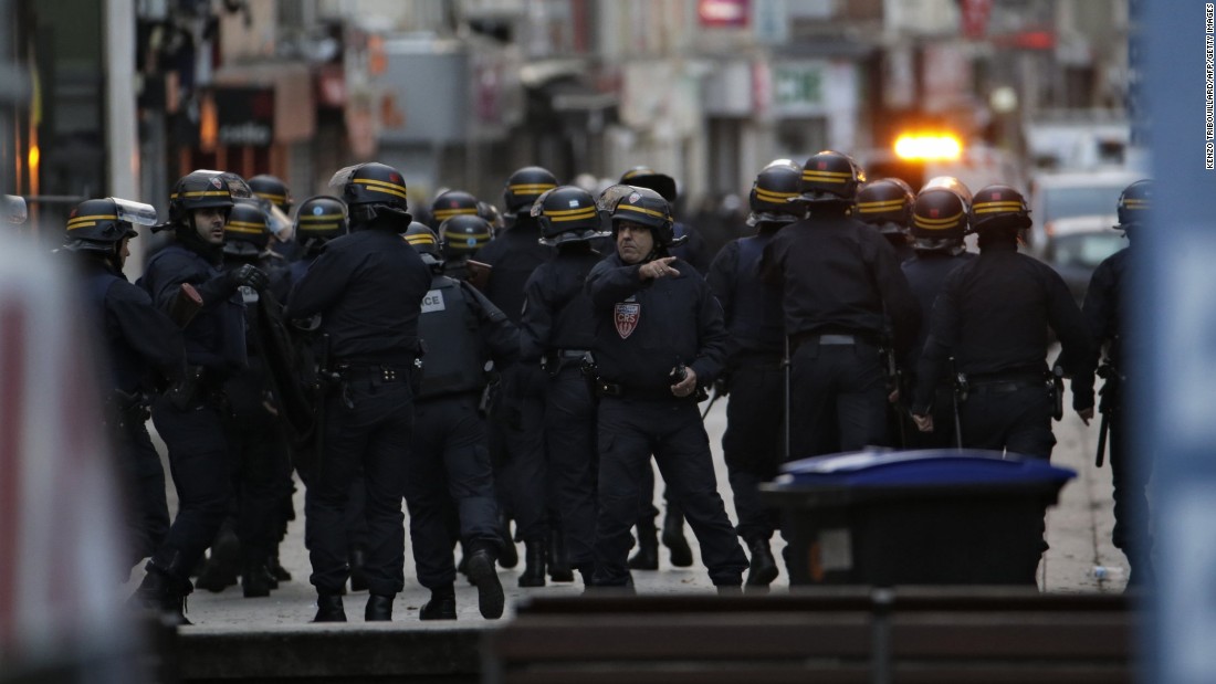 Police take positions during the raid.