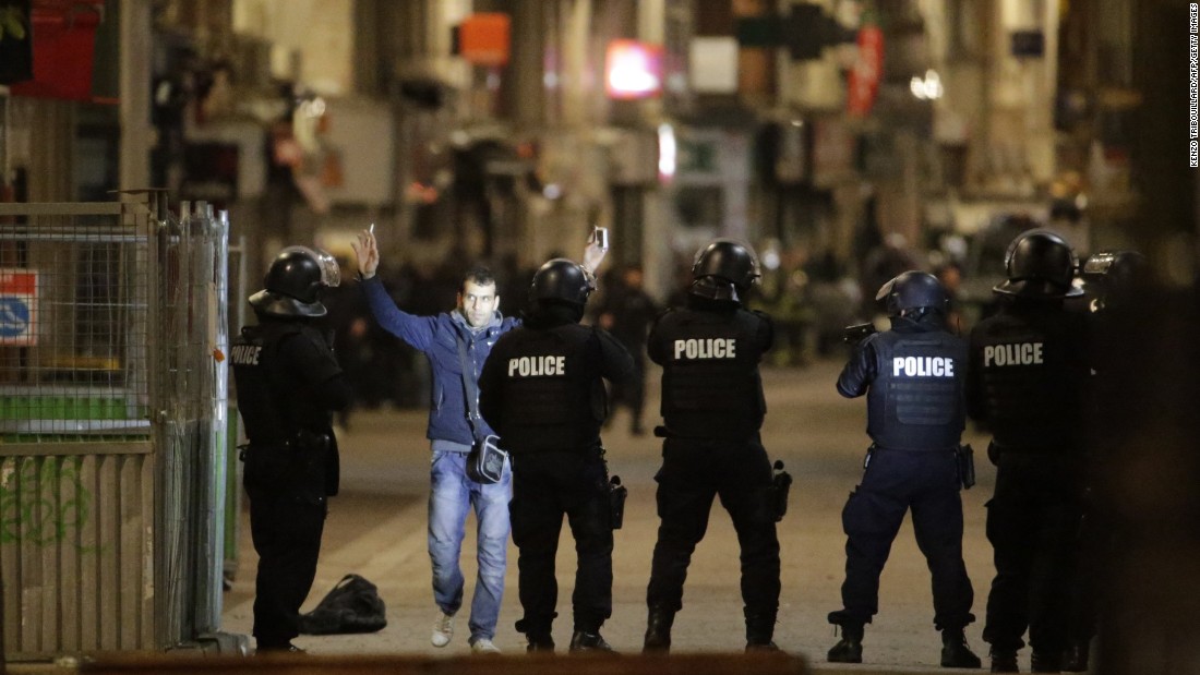 A man approaches a line of police officers during the raid.
