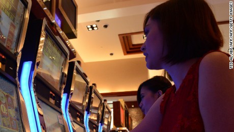Employees of Solaire Manila Resorts and casino pose for photo next to gaming machines inside the casino in Manila on March 14, 2013, ahead of its opening on March 16.  The Philippines makes its biggest bet this weekend in a high-stakes bid to join the world&#39;s elite gaming destinations, with the launch of a $1.2-billion casino on Manila Bay.Solaire Manila Resorts is the first of four enormous entertainment venues slated to rise over a giant chunk of prime, reclaimed land that industry and government leaders expect will attract millions of cashed-up Asian tourists.    AFP PHOTO/TED ALJIBE        (Photo credit should read TED ALJIBE/AFP/Getty Images)