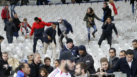 Fans climb down the seats of the Stade de France after the match.