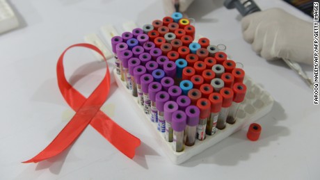 A Pakistani technician takes samples in a laboratory alongside a ribbon promoting the forthcoming World Aids Day in Islamabad on November 30, 2013. The World Health Organization have issued new recommendations to address the specific needs of adolescents both for those living with HIV and those who are at risk of infection. AFP PHOTO/Farooq NAEEM        (Photo credit should read FAROOQ NAEEM/AFP/Getty Images)