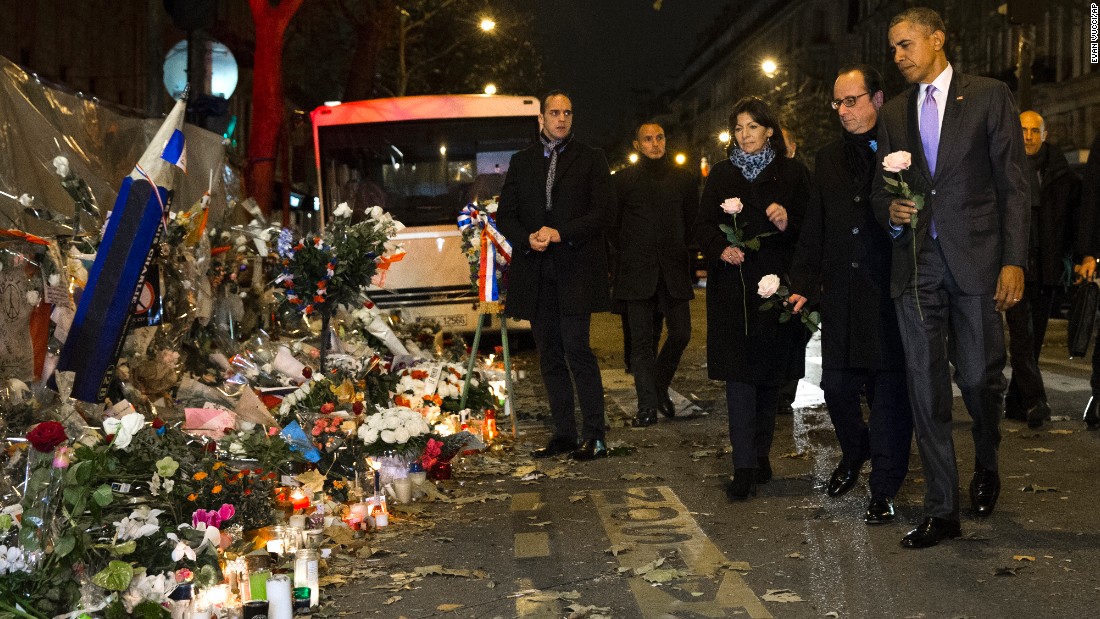 President Barack Obama, French President Francois Hollande, second from right, and Paris Mayor Anne Hidalgo arrive at the Bataclan, site of one of the Paris terrorists attacks, to pay their respects to the victims after Obama arrived in town for the COP21 climate change conference early on Monday, November 30, in Paris. 