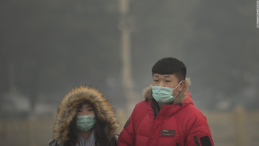 People wearing face masks walk across Tiananmen Square in Beijing on November 28. 