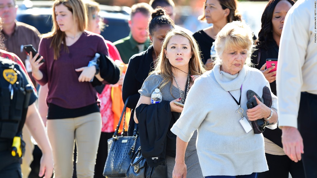 People walk away from the scene. It is unclear how many people were at the facility at the time of the shooting.