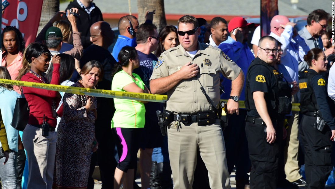 A crowd gathers behind the police line.