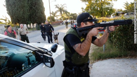 Law enforcement officers search for the suspects of a mass shooting  December 2, 2015 in San Bernardino, California.  A man and a woman suspected of carrying out a deadly shooting at a center for the disabled were killed in a shootout with police, while a third person was detained, police said.        AFP PHOTO / PATRICK T.  FALLON / AFP / Patrick T. Fallon        (Photo credit should read PATRICK T. FALLON/AFP/Getty Images)
