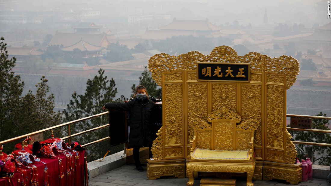 A mask-wearing vendor awaits customers at the Jingshan Park on a polluted day in Beijing on December 7.