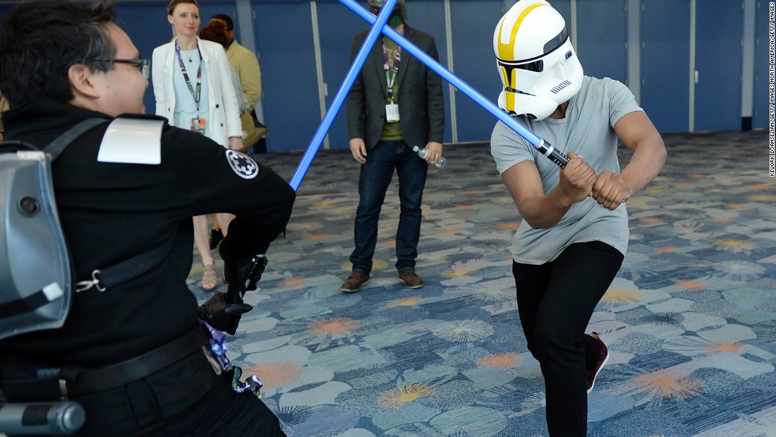 &quot;The Force Awakens&quot; cast member John Boyega wearing a Stormtrooper helmet to disguise his identity engages a unknowing fan in a lightsaber dual during the kick-off event of Disney&#39;s Star Wars Celebration 2015.