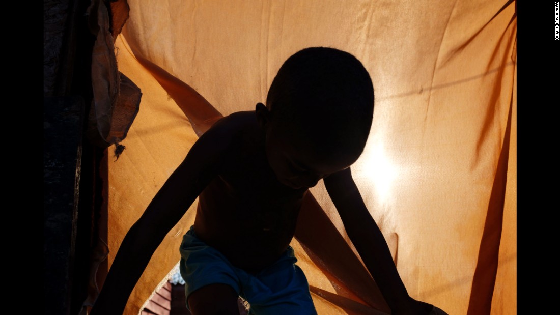 A child comes out of a tent where he lives with his family near Jardim Gramacho, a former landfill that was shut down in 2012.
