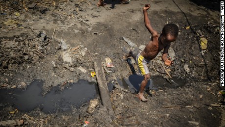 Beira, Mozambique - September 28: A child jumps over a drainage ditch in a slum in the city of Beira on September 28, 2015 in Beira, Mozambique. (Photo by Thomas Trutschel/Photothek via Getty Images)