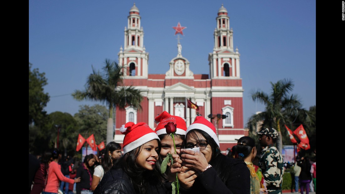 Girls look at photos after taking selfies in front of the Sacred Heart Cathedral in New Delhi on December 25.