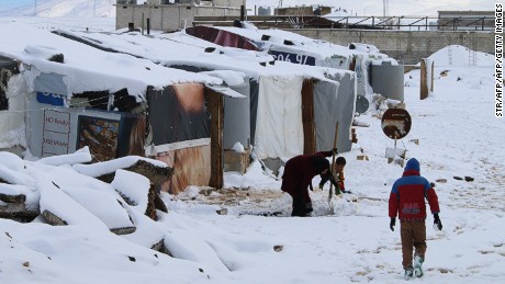 Syrian refugees walk in a makeshift camp in Lebanon last year. 