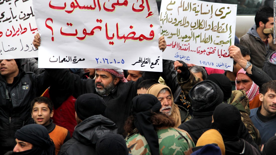 Demonstrators in Idlib, Syria, hold banners in a protest for civilians in besieged Madaya on Tuesday, January 5.