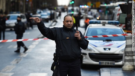 A French police officer redirects traffic at the Boulevard de Barbes in the north of Paris on January 7, 2016, after police shot a man dead as he was trying to enter a police station in the Rue de la Goutte d&#39;Or. A witness told AFP he had heard &quot;two or three shots&quot; in the incident that occurred a year to the day of the jihadist attack on satirical newspaper Charlie Hebdo. The man attempting to attack the police station cried &#39;Allahu Akbar&#39;, was armed with a knife and wore an apparent explosives vest. AFP PHOTO / LIONEL BONAVENTURE / AFP / LIONEL BONAVENTURE        (Photo credit should read LIONEL BONAVENTURE/AFP/Getty Images)