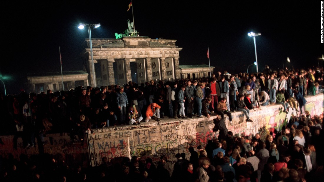 On November 11, 1989, thousands of young East Berliners gather at the Berlin Wall near the Brandenburg Gate as they wait for a crossing into the West to be opened. The fall of East Germany meant the end of life as BFC had known it.