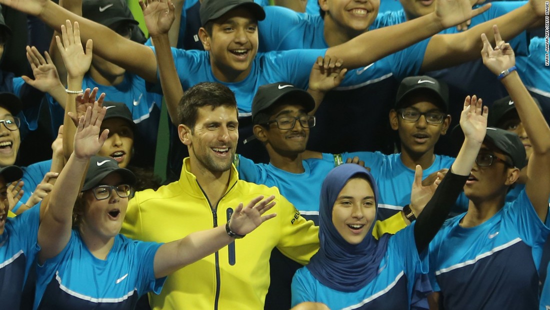 Novak Djokovic poses for a picture with the tournament&#39;s ballboys and girls after thrashing Rafael Nadal of Spain in the final Qatar Open in Doha.