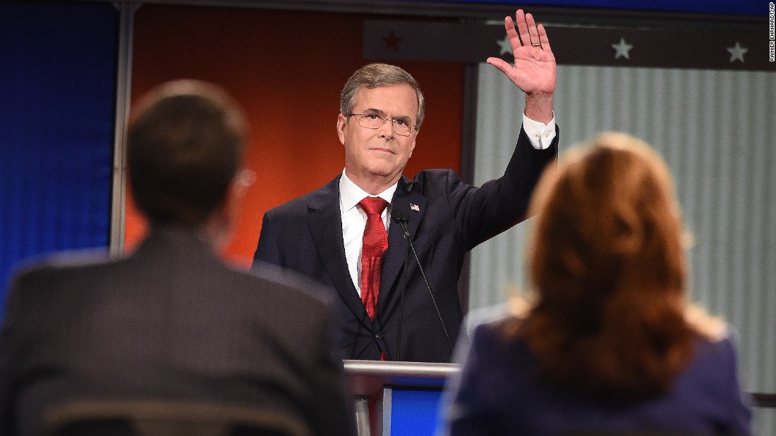 Bush waves to the audience. The former Florida governor has been trying to build momentum that he had in the early stages of his candidacy, and he went after Democratic candidate Hillary Clinton early in the debate. &quot;She&#39;s under investigation with the FBI right now,&quot; he said. &quot;If she gets elected, her first 100 days, instead of setting an agenda, she might be going back and forth between the White House and the courthouse. We need to stop that.&quot;