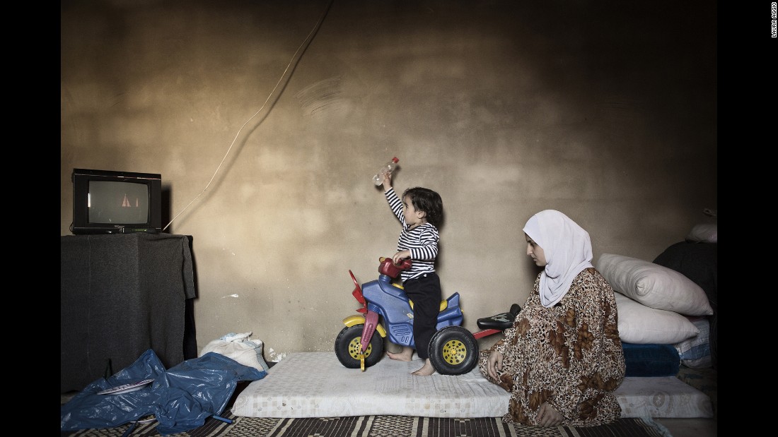 Marwa, 15, watches her son play on a tricycle. She married three years ago and left Syria a year after that.