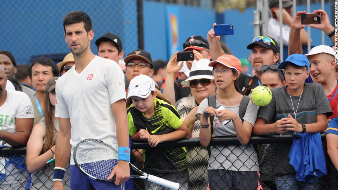 Fans get up close and personal to Novak Djokovic during a practice session at Melbourne Park.