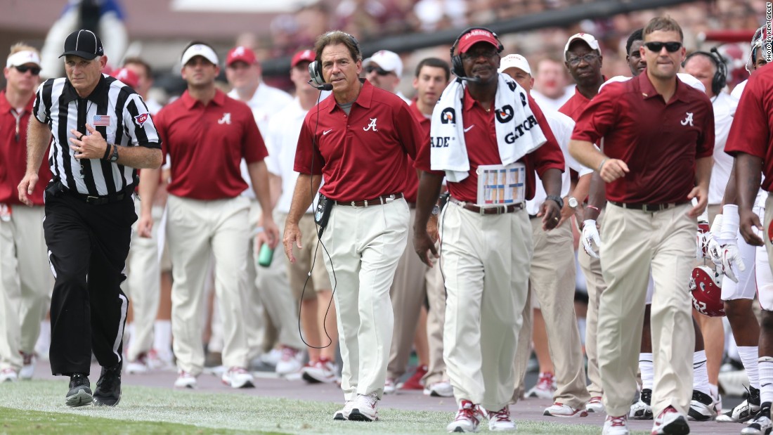 Moawad (far right, in glasses) has earned five National Championship rings -- four of them at the University of Alabama under football coach Nick Saban (third right.) 