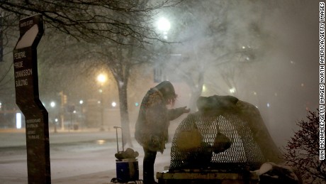 WASHINGTON, DC - JANUARY 22:  A homeless woman tires to keep warm near a steam grate on Constitution Avenue January 22, 2016 in Washington, DC. A major snowstorm is forecasted for the East Coast this weekend with some areas expected to receive up to 30 inches of snow .  (Photo by Win McNamee/Getty Images)