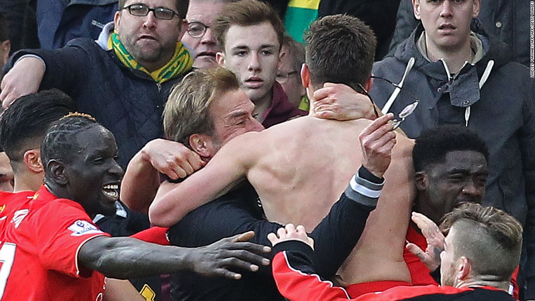 A shirtless Adam Lallana celebrates with teammates and manager Jurgen Klopp as Liverpool claim a dramatic 5-4 victory at Norwich City.