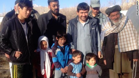 Murtaza poses with local villagers, including his proud father Arif, in the blue vest, third from right.