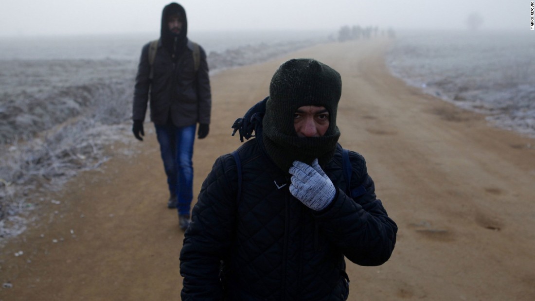 Two men from Syria walk in dense fog along a path connecting a registration center with the town of Miratovac. Because of bad weather and muddy roads, buses were waiting for them 2 kilometers (1.2 miles) from there. They were taking them to the Croatian border.
