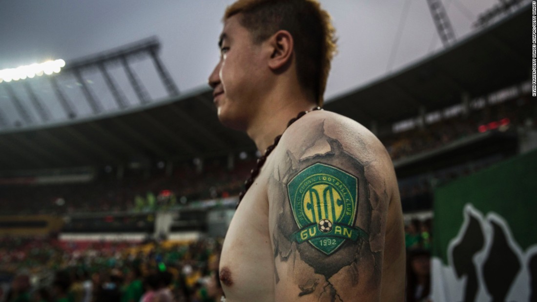 An Ultra supporter of Beijing Guoan shows a tattoo of the team&#39;s badge during a match against Chongcing Lifan.