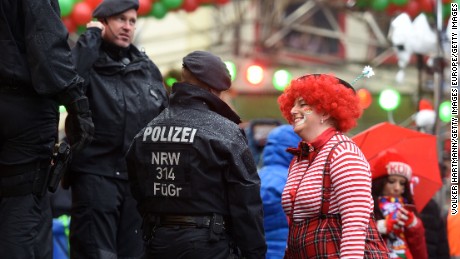 A woman in fancy dress speaks to the police as she takes part in Cologne&#39;s annual Carnival celebration.
