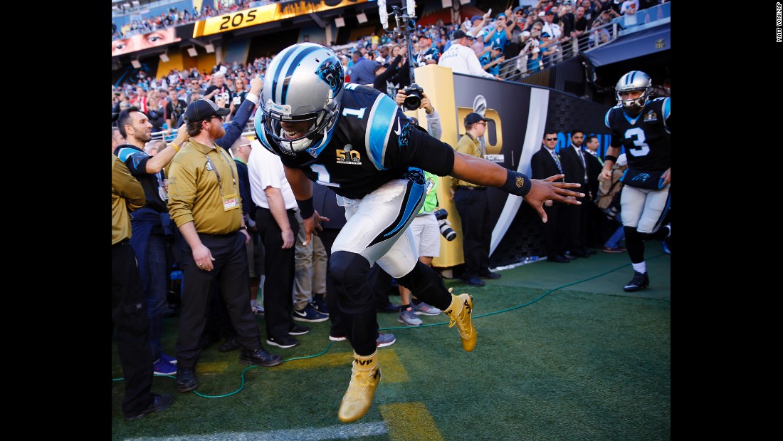 Newton and the Panthers run onto the field before the game.