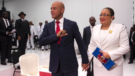 Michel Martelly, Haiti&#39;s outgoing President, stands with his wife, Sophia, before they leave parliament chambers in Port-au-Prince on Sunday.  