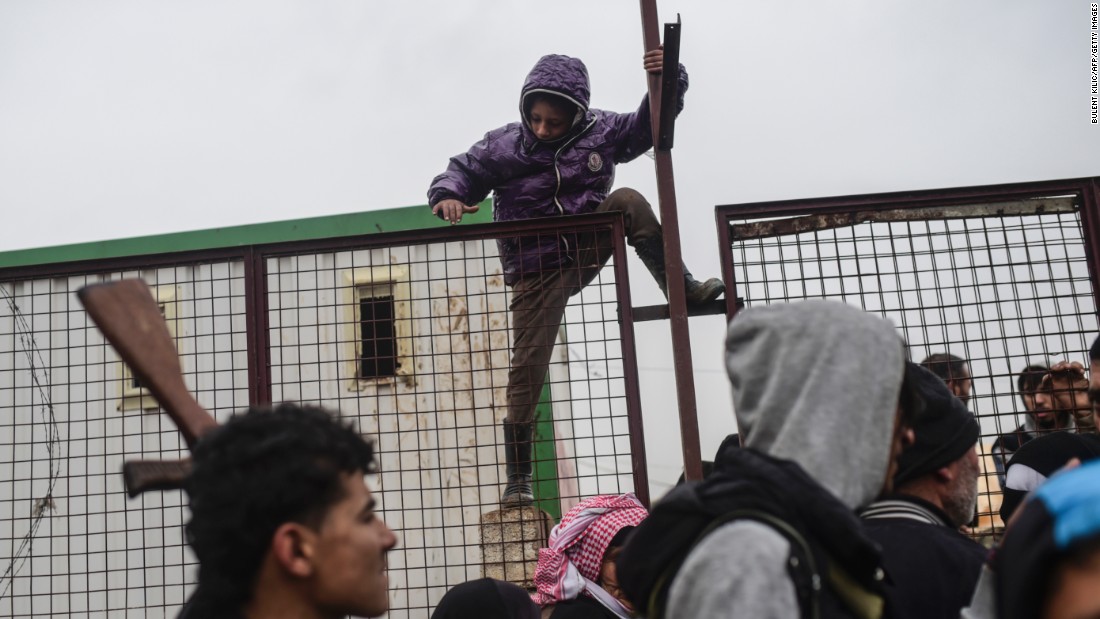 A child tries to climb over a fence near the Turkish border as Syrians fleeing the northern city of Aleppo wait on February 6.