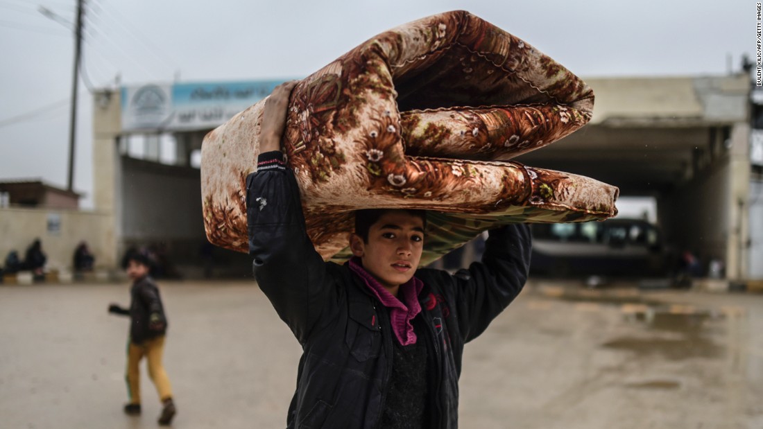 A young refugee carrying belongings arrives at the Turkish border on February 6.