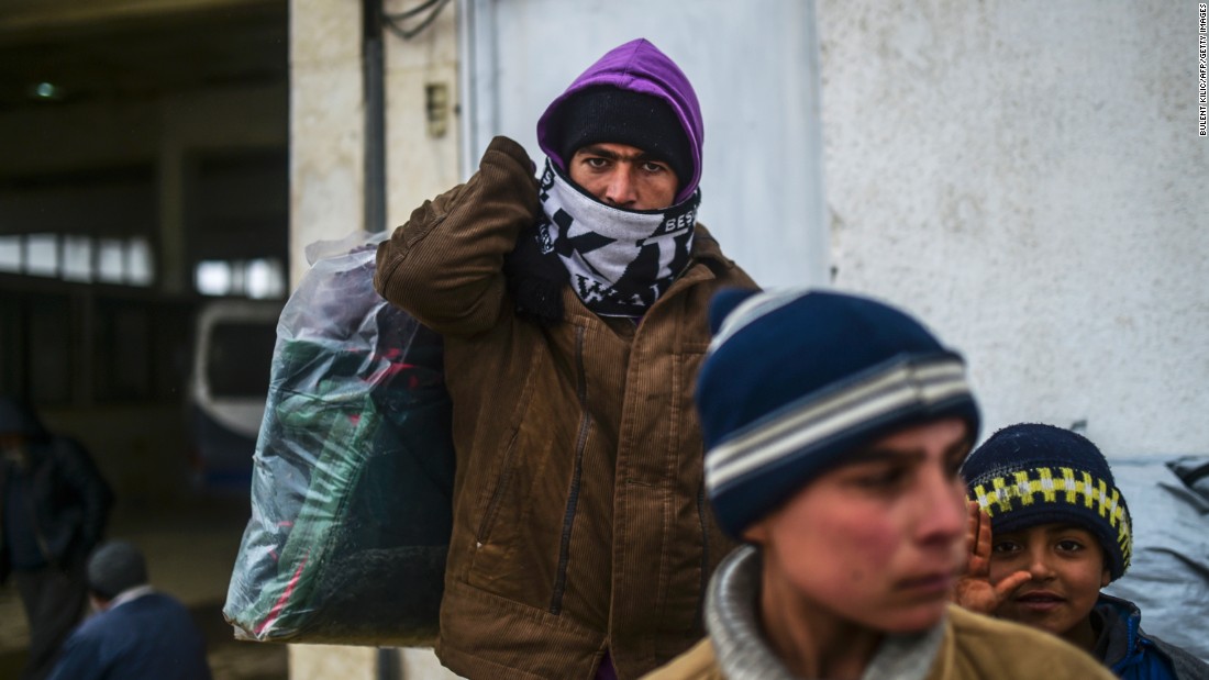 A refugee carries a heavy bag of items near the Turkish border gate on February 6.