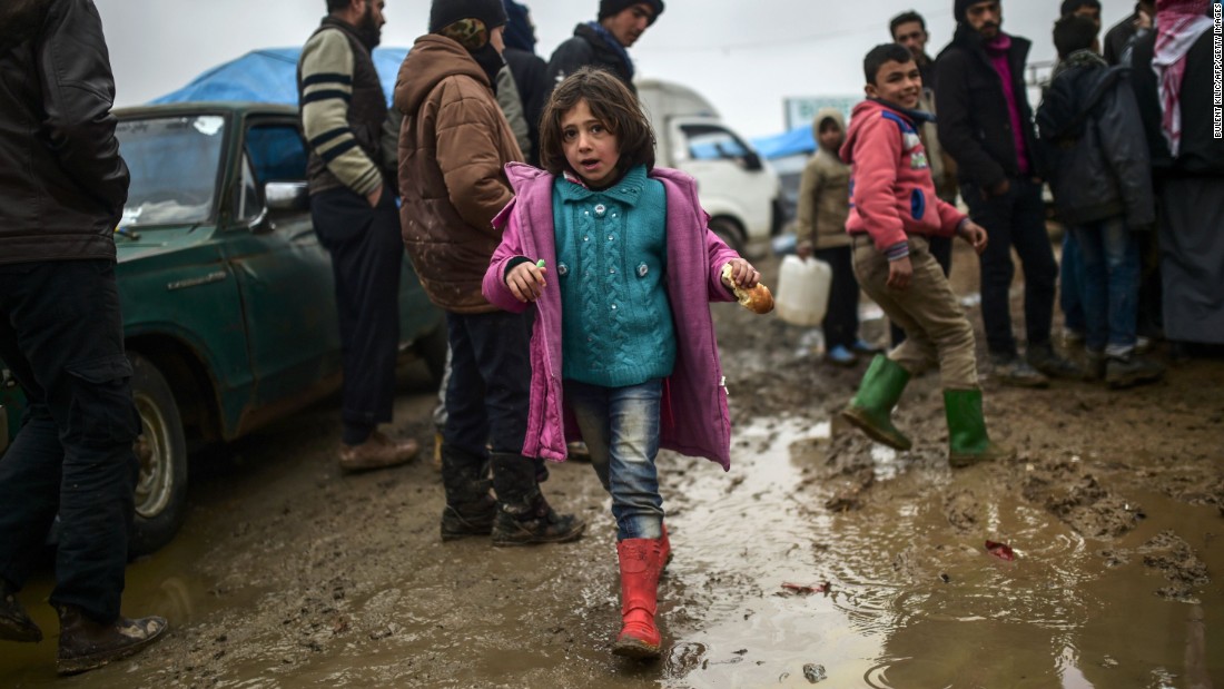 Refugees brave the cold and rain as they arrive at the Turkish border on February 6.