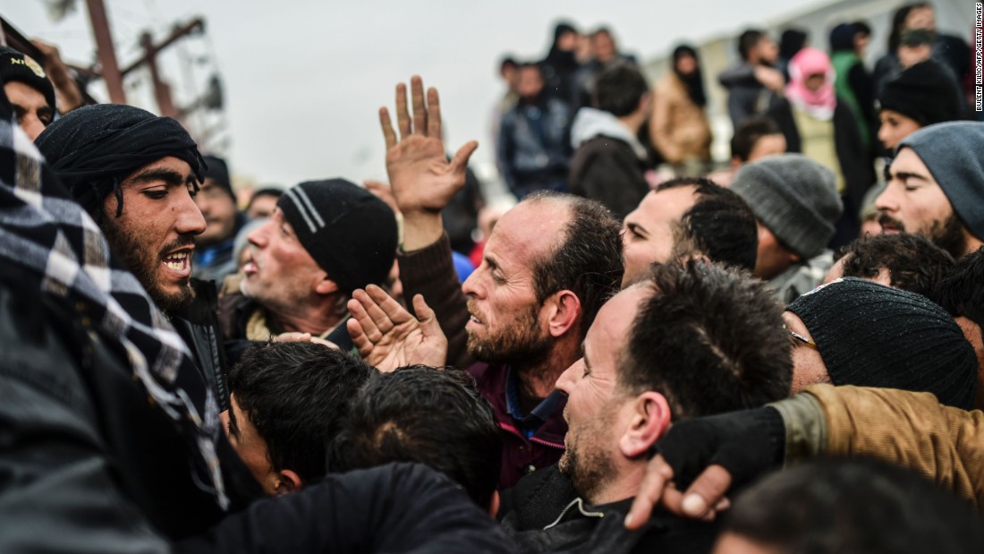 Refugees push each other as they wait for tents near the Turkish border on February 6.