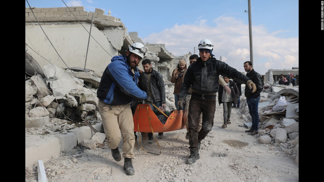 Members of the &quot;White Helmets&quot; civil defense volunteers carry the body of a man killed in a Russian airstrike in Andan town in the countryside north of of Aleppo.