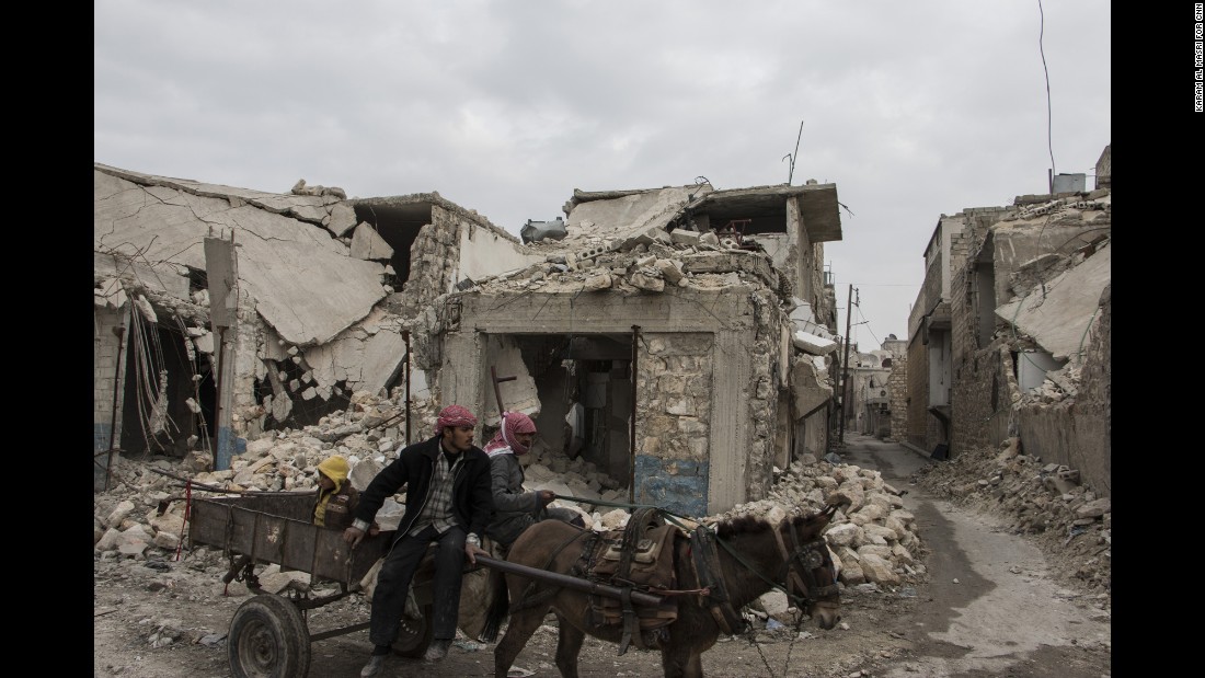 Two men and their donkey navigate the bombed alleyways of Almarja district in eastern Aleppo.