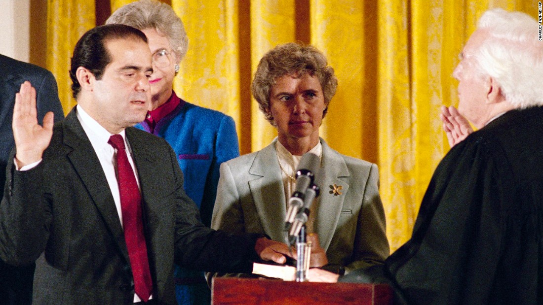 Retiring Chief Justice Warren Burger, right, administers the oath to Scalia, as Scalia&#39;s wife, Maureen, holds the Bible on September 26, 1986. Scalia was the 103rd person to sit on the court. 