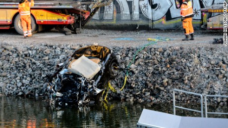 A damaged car is pulled from a canal in Sodertalje, Sweden, on Saturday.