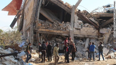 People gather around the rubble of a hospital supported by Doctors Without Borders (MSF) near Maaret al-Numan, in Syria&#39;s northern province of Idlib, on February 15, 2016, after the building was hit by suspected Russian air strikes. 