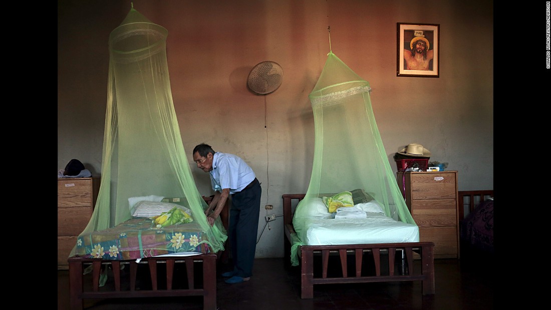 A man places a mosquito net over a bed at a home for the elderly in Masaya, Nicaragua, on Thursday, February 11.