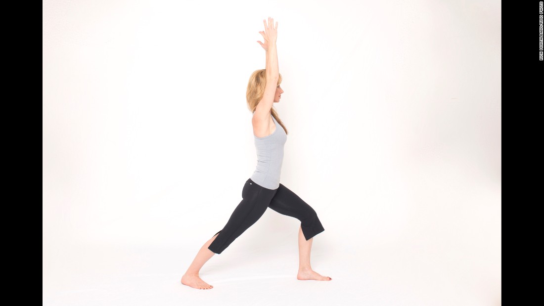 From standing, step your right leg back into a lunge but drop your heel all the way down and point your toes out slightly. Keep your back leg straight with your forward knee flexed to align above your ankle. Lift your arms overhead, shoulder-distance apart, keeping the shoulder blades stable down the back to maintain length in your neck. 